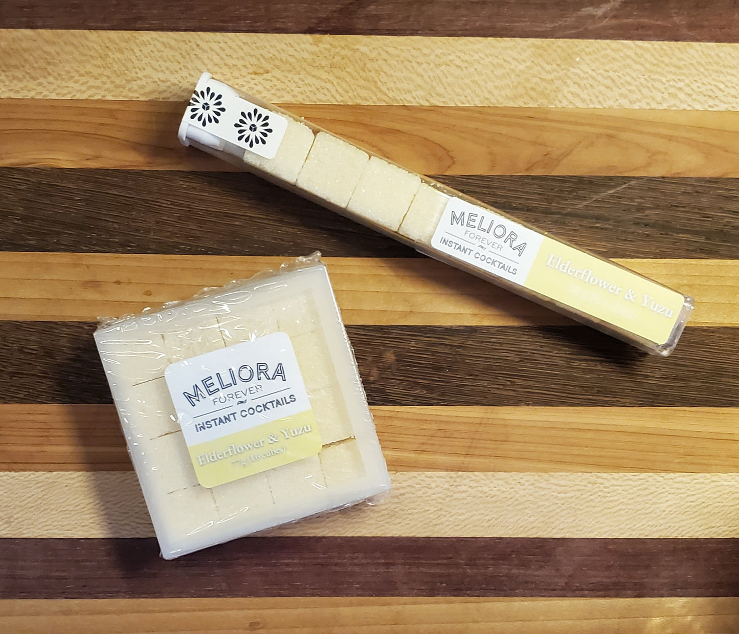 Elderflower and Yuzu instant cocktail cubes, which are Cane Sugar Cubes infused with bitters, fruits, and natural flavors. There are two packages shown, including an 8-count tube, and a 16-count box.