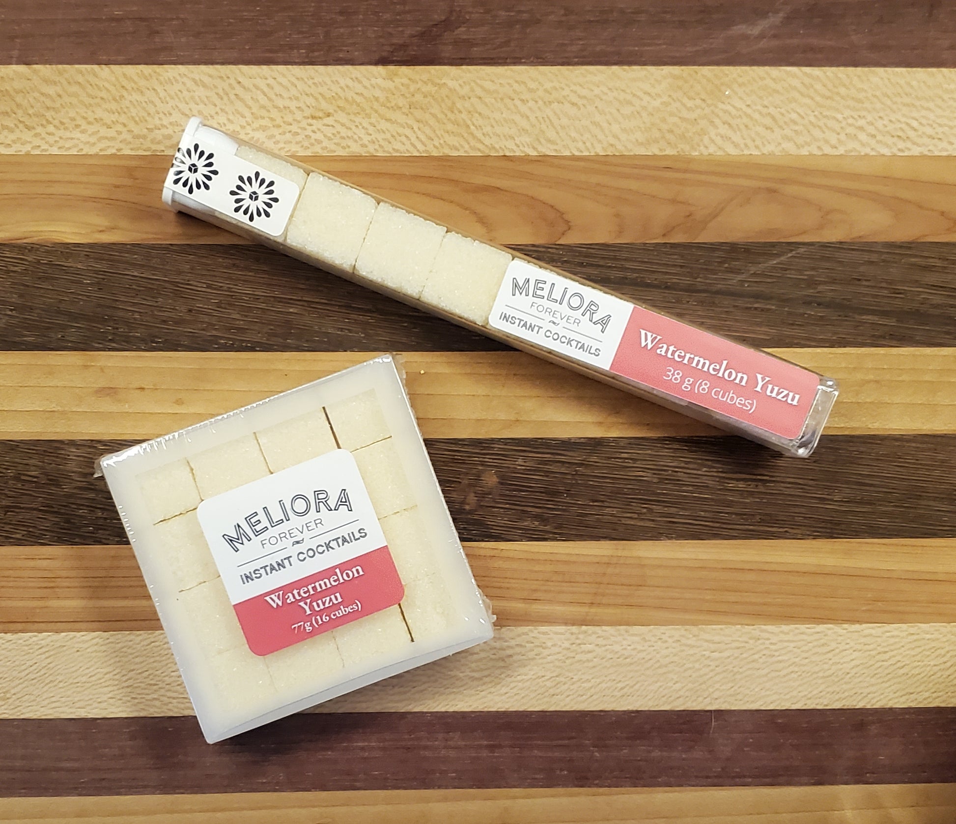 Watermelon Yuzu instant cocktail cubes, which are Cane sugar cubes infused with bitters, fruits, and natural flavors. There are two packages shown, including an 8-count tube, and a 16-count box.
