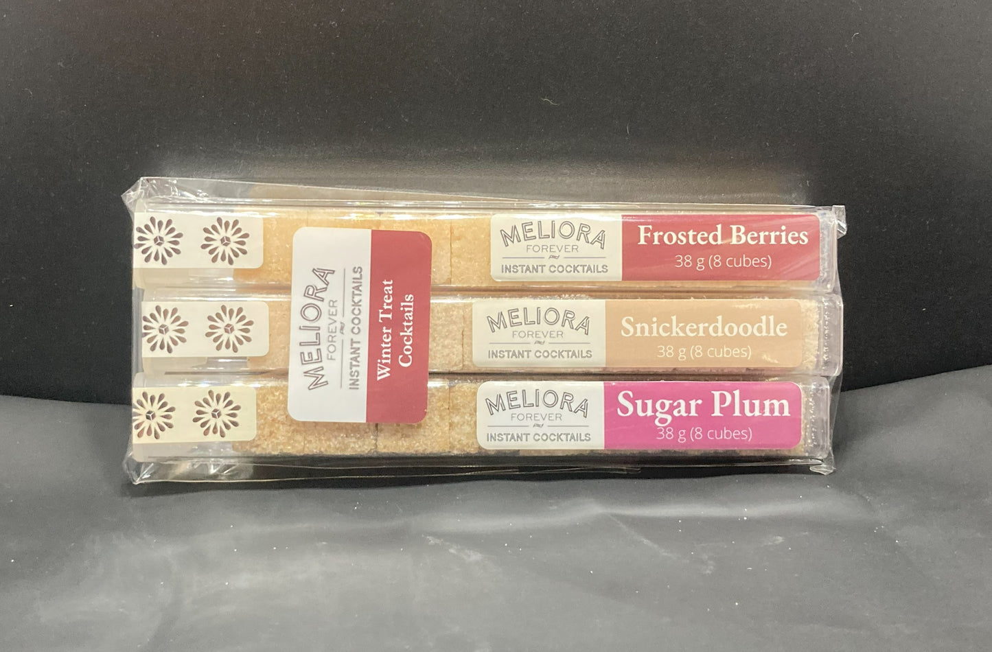 Winter Treat instant cocktail cubes, including 3 different flavors. Sugar cubes infused with bitters, fruits, and natural flavors. Each flavor is packaged in an 8 Count tube. Flavors include Frosted Berries (Cherry & Berries), Snickerdoodle (Cinnamon, Vanilla) and Sugar Plum.